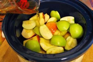 Step two is adding the juice to the cut apples in the slow cooker.