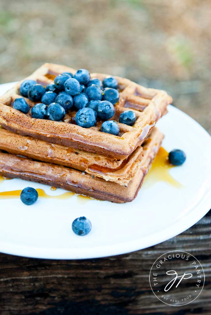 A plate of waffles topped with fresh blueberries, made with this homestyle waffles recipe.