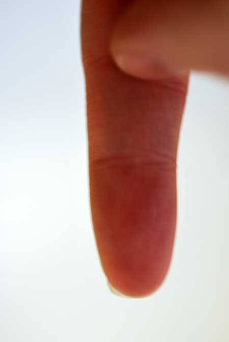 Photo of a finger pointing to the second knuckle. The point at which you fill the water to.