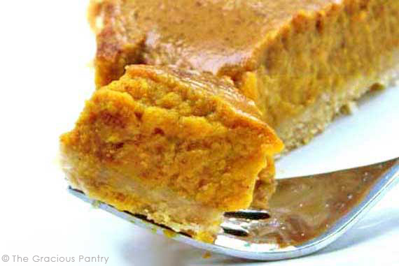 A single slice of Pumpkin Pie With a fork holding a piece of it.