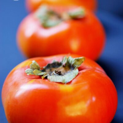 A row of persimmons sit waiting to be made into this Persimmon Butter Recipe.