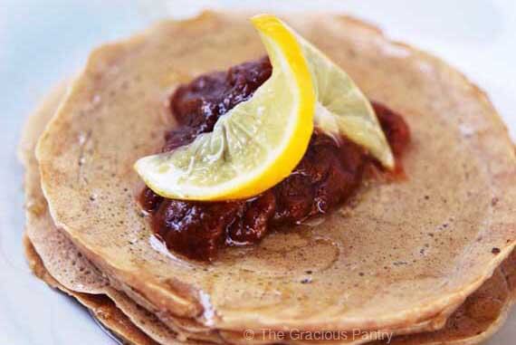 A closeup of a white plate holding as short stack of whole wheat pancakes.