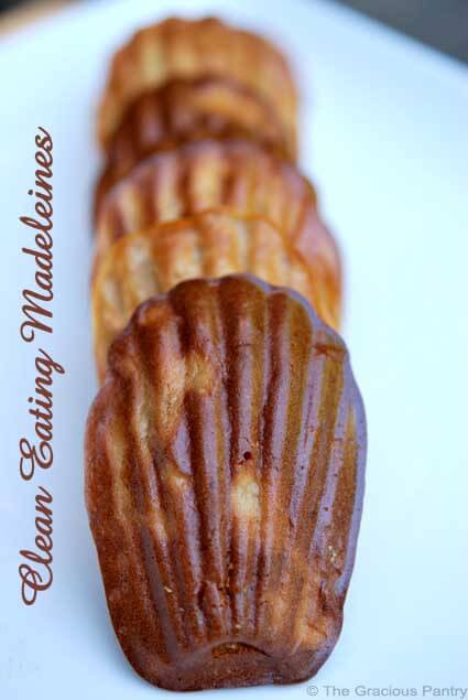 A single file line of madeleines sits on a light blue background in this Clean Eating Desserts Cookbook.