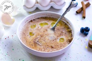 Step one of this Healthy French Toast Recipe shows the eggs, milk and cinnamon mixed in a bowl.