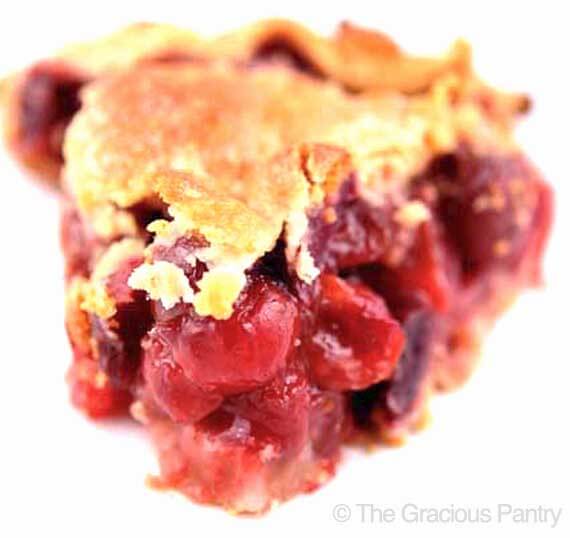 A slice of Clean Eating Cherry Pie on a white background, shown up close so you can see the cherries.