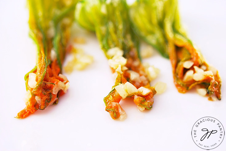 A row of three, cooked squash blossoms.