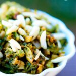 A white bowl filled with this Garlic Broccoli sits on a table, ready to serve.