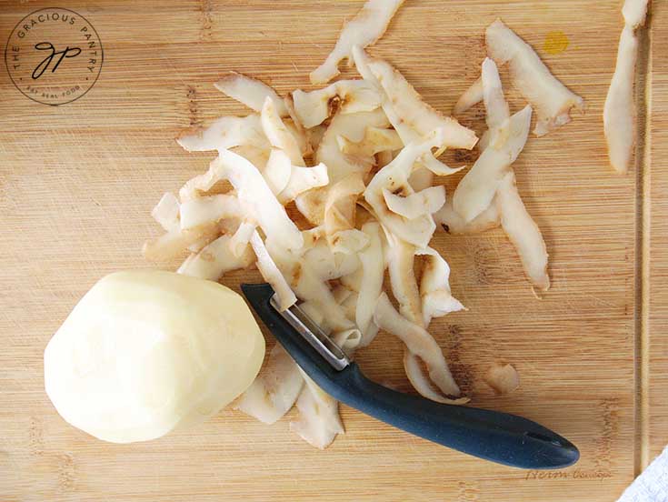 Step 1 is to wash and peel your potatoes in this homemade hash browns recipe.