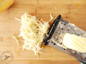 Step 2 is to grate the potatoes.
