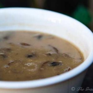 A small white bowl is filled with homemade cream of mushroom soup.