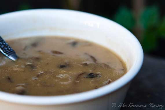 A small white bowl is filled with homemade cream of mushroom soup.