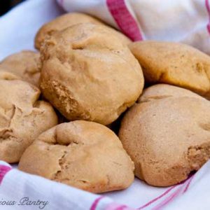 Several Homemade Dinner Rolls in a towel-lined basket.