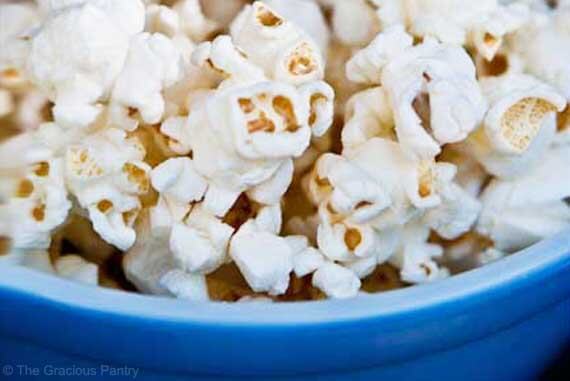 A bowl of coconut oil popcorn on a dark background.