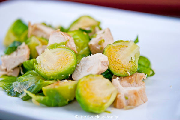 A white plate holds a serving of Chicken And Brussels Sprouts.