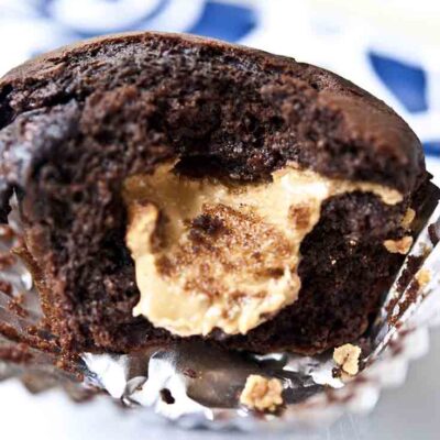 A chocolate chocolate chip muffin, broken open and showing a peanut butter center.