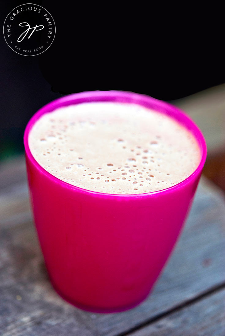 A short, pink cup sits filled with this Chocolate Milkshake.