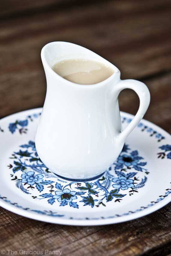 A small white pitcher filled with condensed milk in this post on how to make condensed milk.