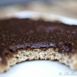 A close up of a piece of bread on a plate, with Nutella spread over the top.