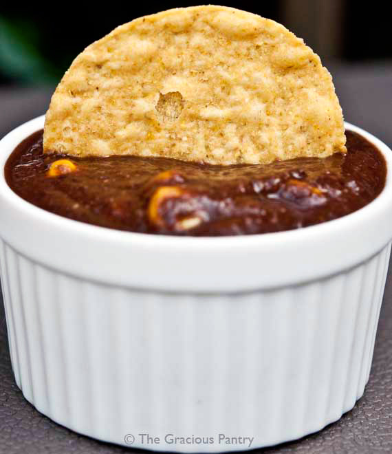 Clean Eating Southwest Black Bean Dip served in a white bowl with a single corn chip sitting in the dip.