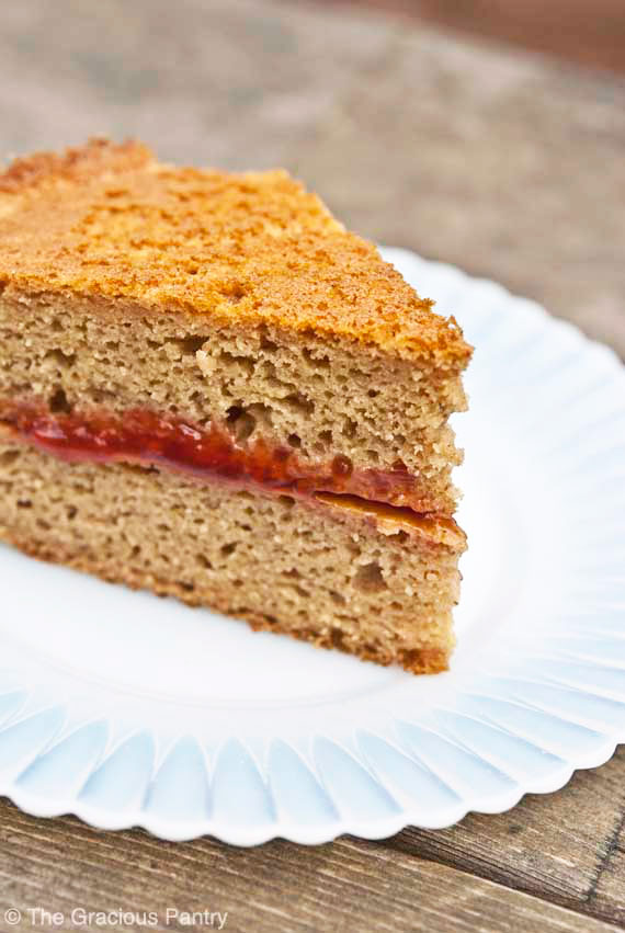 A single slice of Whole Wheat Cake with raspberry filling on a white plate.