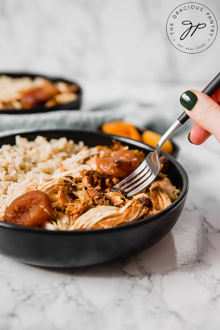 You can see somebody holding a fork, getting ready to take a bite of this Clean Eating Curry Chicken Recipe. You see only the hand holding the fork which is dipping into the dish.