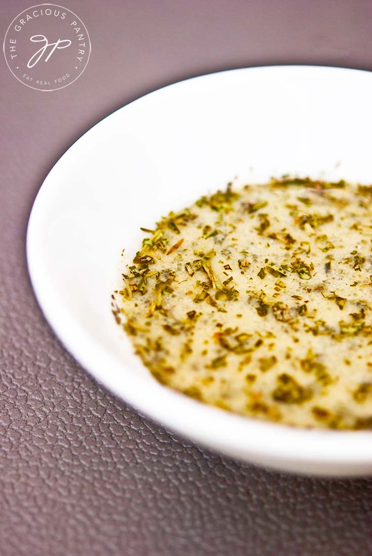 A small, white bowl sits filled with this Tarragon Dijon Dressing, ready to pour over your salad.