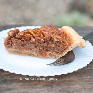 A slice of naturally sweetened pecan pie on a white plate.