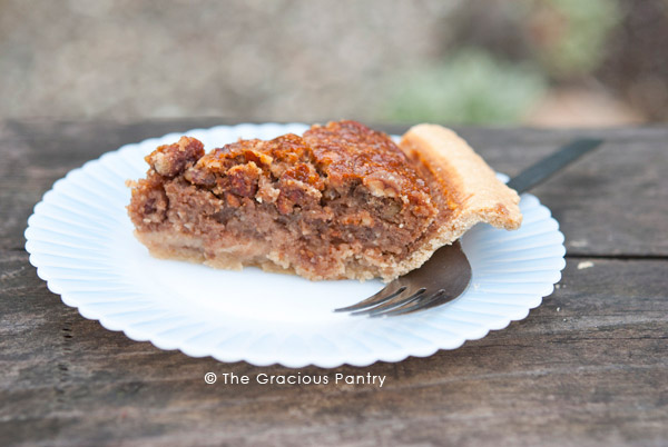 A slice of naturally sweetened pecan pie on a white plate.
