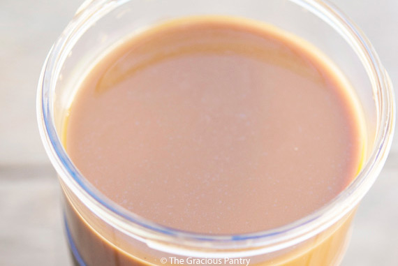 A close up view of a coconut latte in a clear cup.