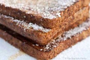 Three sliced stacks of coconut french toast on a white plate.