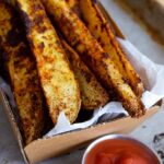 Potato Wedges served in a basket with a side of ketchup.