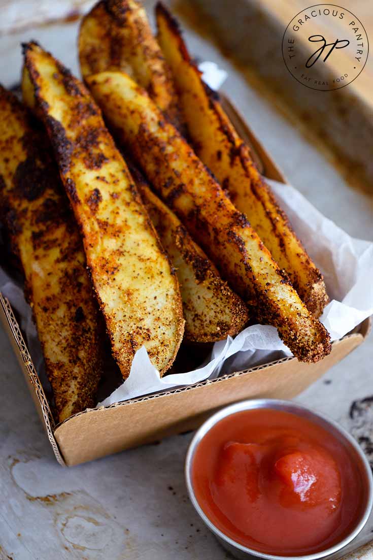 Potato Wedges served in a basket with a side of ketchup.