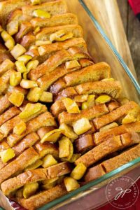 This Apple French Toast Casserole freshly out of the oven and topped with maple syrup.