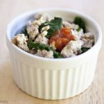 A single, white bowl on a wood background. It's filled with ground turkey scramble.