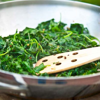 This baby kale recipe sits in a steel skillet after just being cooked.