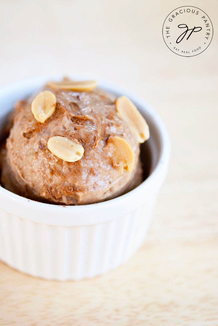 Clean Eating Chocolate Peanut Butter Banana Ice Cream in a bowl with peanuts sprinkled on top.