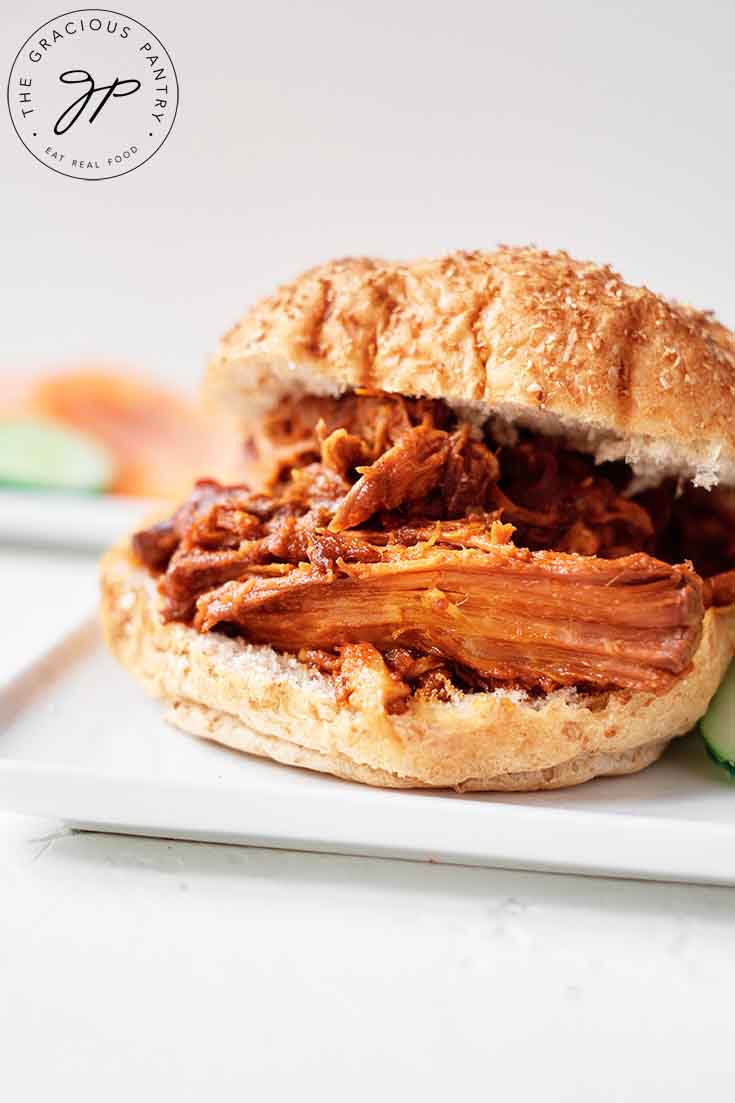 A single Pulled Pork Sandwich on a plate with the top bun offset.