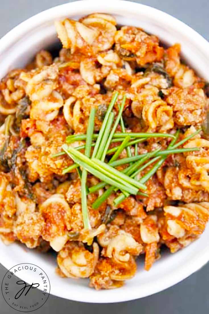 An overhead view of this Superfood Rotini Recipe, looking down into the bowl of pasta. It's garnished with fresh chives.