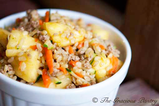 A Curry Pineapple Turkey Rice Bowl on a wood surface.