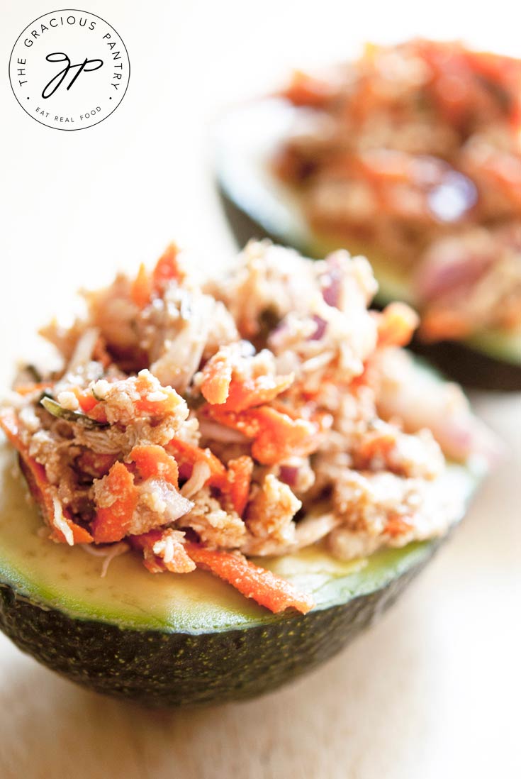 This Clean Eating Chicken Avocado Salad is shown up close with the chicken salad served on top of a half of an avocado.