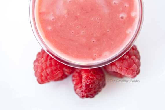 An overhead view looking down into a bowl of this Clean Eating Raspberry Vinaigrette. It has a bright pink color and is ready to serve!