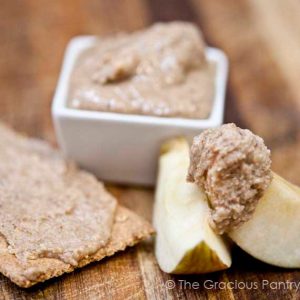 Cinnamon Almond Butter in a small dish with apple slices sitting next to it.