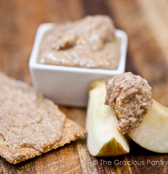 Cinnamon Almond Butter in a small dish with apple slices sitting next to it.