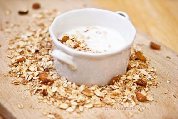 A small white bowl filled with milk and cold cereal.