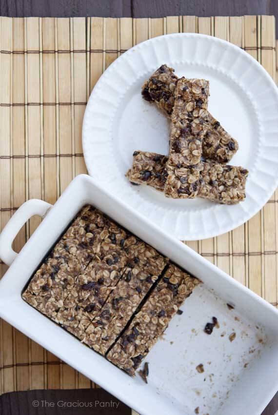 An overhead view looking down into a white, ceramic casserole dish, partially filled with no bake oatmeal granola bars.