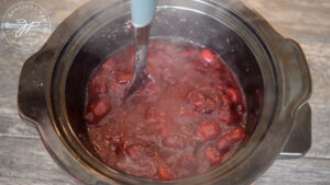 Mashing the cooked cranberries.