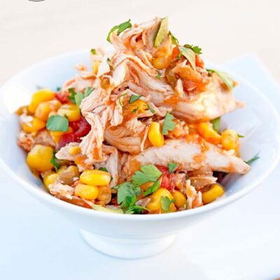 A full bowl of this Sweet And Spicy Crock Pot Chicken sits on a table, ready to eat.