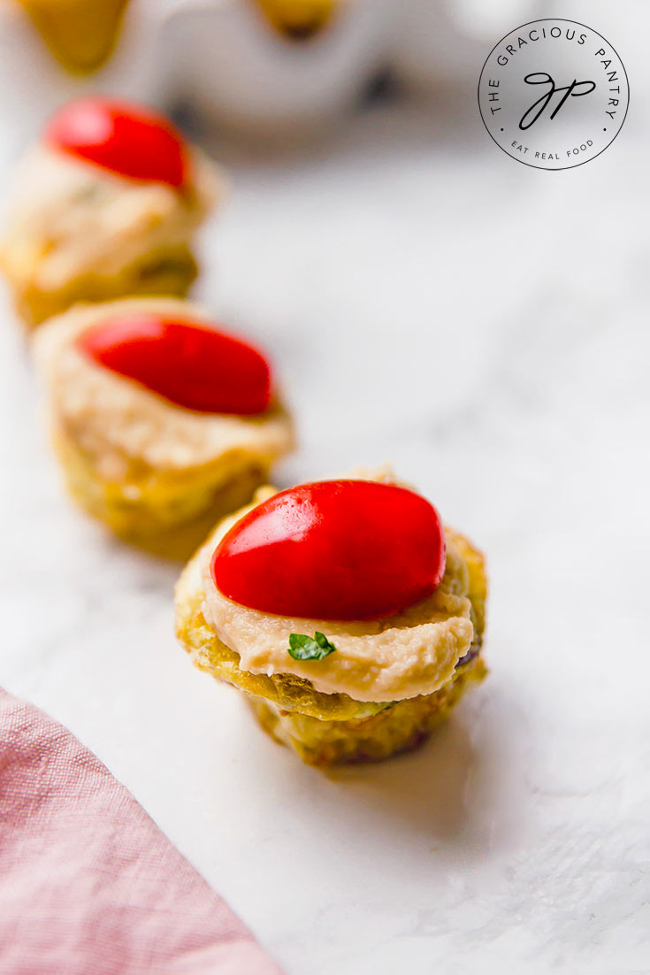 A single row of quiches from this Mini Quiche Recipe. A carton sits behind the row, ready to hold the mini quiches.