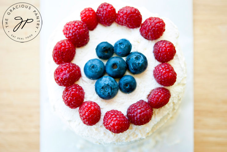 An overhead view looking down at the top of this Clean Eating Watermelon Cake. You can see the berries surrounding the top of the whipped cream covered cake.