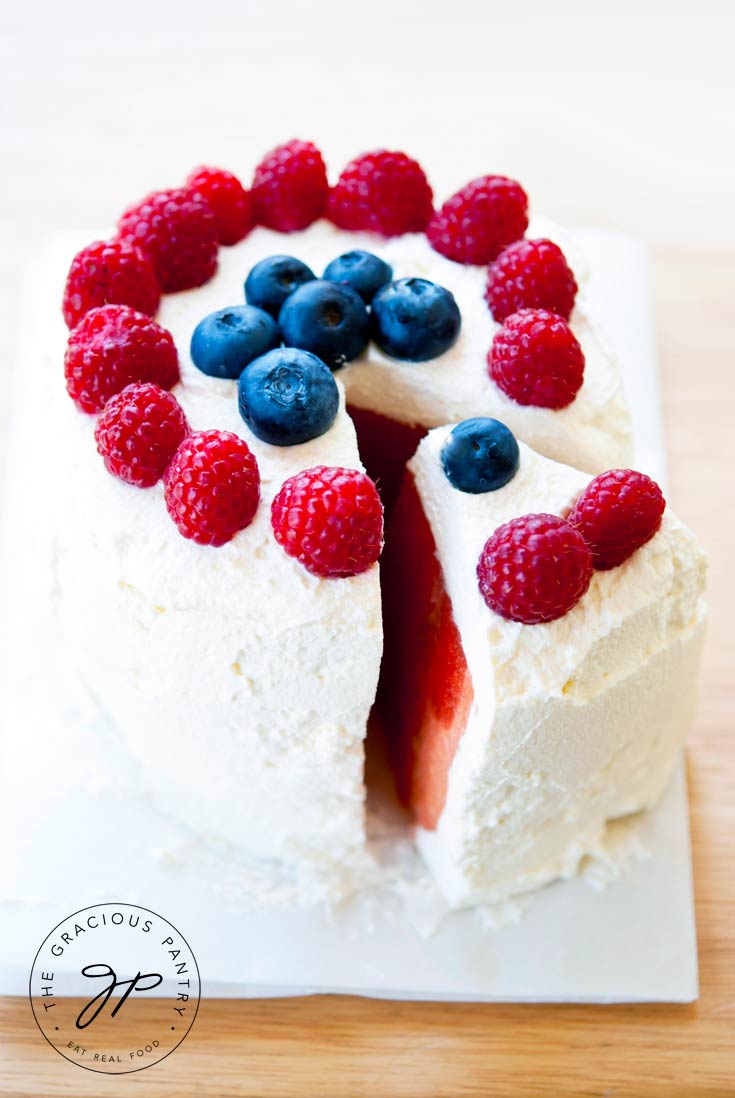 Here, the Clean Eating Watermelon Cake is cut with a slice partially removed so you can see the pink inside of the melon.